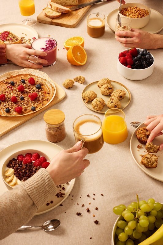 “Homemade healthy brunch with overnight oats, granola bowls, fresh fruit, muffins, cookies, nut butter, and coffee on a cozy breakfast table.